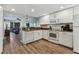 White kitchen with granite counters and wood-look floors at 12000 Gulf Blvd # 309N, Treasure Island, FL 33706