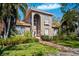 Charming two-story home with a tile roof, arched windows, manicured landscaping, and inviting curb appeal at 1388 Brightwaters Ne Blvd, St Petersburg, FL 33704