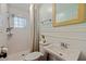 Updated bathroom with subway tile shower, pedestal sink, and decorative mirror at 2790 Pinellas Point S Dr, St Petersburg, FL 33712