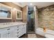 Bathroom with double vanity, walk-in shower, and stone feature wall at 2790 Pinellas Point S Dr, St Petersburg, FL 33712