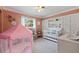 bedroom with crib, play tent, and built-in shelving at 2790 Pinellas Point S Dr, St Petersburg, FL 33712