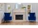 Elegant fireplace with ornate mantelpiece and blue velvet armchairs at 2790 Pinellas Point S Dr, St Petersburg, FL 33712