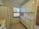 Well-equipped kitchen with white cabinets, tile countertops, and extra storage at 2991 Flint S Dr # 77-D, Clearwater, FL 33759