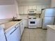 White kitchen with ample cabinetry, tile countertops, and built-in appliances at 2991 Flint S Dr # 77-D, Clearwater, FL 33759
