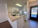 Efficient kitchen featuring white cabinetry, tile countertops, and a breakfast bar at 2991 Flint S Dr # 77-D, Clearwater, FL 33759