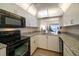 Modern kitchen with granite countertops and black appliances at 3100 Gulf Blvd # 424, Belleair Beach, FL 33786