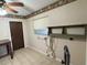 Bright laundry room with built-in shelving and tile floor at 3922 Lake Joyce Dr, Land O Lakes, FL 34639