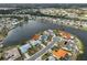 Aerial view of a lakeside home on a peninsula featuring mature landscaping and serene water views at 407 Blackhawk Cir, Sun City Center, FL 33573