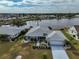 An aerial view of a home, featuring a well-manicured lawn, lakeside access, and neighborhood at 407 Blackhawk Cir, Sun City Center, FL 33573