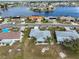 Aerial perspective showcasing a community with well-kept lawns and homes surrounding a tranquil lake at 407 Blackhawk Cir, Sun City Center, FL 33573