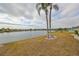 Backyard view overlooking the water, complemented by mature palm trees at 407 Blackhawk Cir, Sun City Center, FL 33573