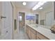 Bathroom with a long countertop, big mirror, white cabinets and tile floors at 407 Blackhawk Cir, Sun City Center, FL 33573