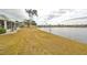 Lakeside home showcasing a serene view of the water, enhanced by palm trees and lush green surroundings at 407 Blackhawk Cir, Sun City Center, FL 33573