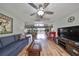 Bright living room with hardwood floors, ceiling fan, and comfortable furnishings at 407 Blackhawk Cir, Sun City Center, FL 33573