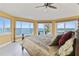 Main bedroom with water views, king-size bed, and ceiling fan at 6119 Gnarled Oak Ln, Englewood, FL 34223