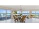 Bright dining room with water views and glass table for six at 6119 Gnarled Oak Ln, Englewood, FL 34223
