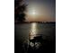 Night view of waterfront with dock and full moon at 6119 Gnarled Oak Ln, Englewood, FL 34223
