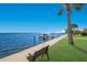 Scenic waterfront walkway with a bench and dock at 6119 Gnarled Oak Ln, Englewood, FL 34223