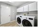 Laundry room with washer, dryer, and overhead cabinets at 15106 Meadowlake St, Odessa, FL 33556