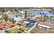 An aerial view of a home with a screened-in pool, water view, and manicured landscaping at 1720 Flamingo Ln, Sun City Center, FL 33573