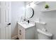 Well lit modern bathroom featuring a white vanity, floating shelves, and door at 1720 Flamingo Ln, Sun City Center, FL 33573