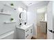 Bright bathroom with floating shelves, modern vanity, round mirror and view of the bedroom at 1720 Flamingo Ln, Sun City Center, FL 33573