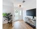 Bright entryway features a decorative glass front door, hardwood floors, and a stylish console table with a large-screen TV at 1720 Flamingo Ln, Sun City Center, FL 33573