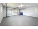 Spacious two-car garage featuring a light gray floor and a white garage door at 1720 Flamingo Ln, Sun City Center, FL 33573