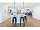 Modern kitchen features white cabinetry, quartz countertops, stainless steel appliances, island with bar seating and hardwood floors at 1720 Flamingo Ln, Sun City Center, FL 33573