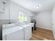 Clean laundry room with modern appliances, wood flooring and a wash sink at 1720 Flamingo Ln, Sun City Center, FL 33573
