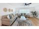 Cozy living room with hardwood floors, shiplap accent wall, modern ceiling fan, and comfortable seating arrangement at 1720 Flamingo Ln, Sun City Center, FL 33573