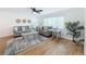 Cozy living room with hardwood floors, shiplap accent wall, modern ceiling fan, and comfortable seating arrangement at 1720 Flamingo Ln, Sun City Center, FL 33573