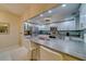 Modern white kitchen with stainless steel appliances and breakfast bar at 6 Belleview Blvd # 105, Belleair, FL 33756