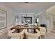 Open concept dining room with a long wooden table and modern white chairs at 17554 Holly Well Ave, Wimauma, FL 33598
