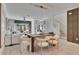 Open dining room with wooden table and white chairs at 17554 Holly Well Ave, Wimauma, FL 33598