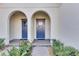 Front entry with two blue doors at 17554 Holly Well Ave, Wimauma, FL 33598