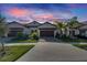 Two-story home with brown garage door and landscaping at 17554 Holly Well Ave, Wimauma, FL 33598