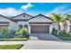 Tan two-story home with brown garage door at 17554 Holly Well Ave, Wimauma, FL 33598