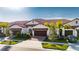 Tan two-story home with brown garage doors at 17554 Holly Well Ave, Wimauma, FL 33598