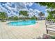 Relaxing resort-style pool with palm trees and lounge chairs at 17554 Holly Well Ave, Wimauma, FL 33598