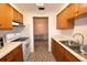 Kitchen with wood cabinets, white appliances, and view into dining area at 4315 Aegean Dr # 110C, Tampa, FL 33611