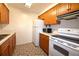 View of kitchen with white appliances and wood cabinets at 4315 Aegean Dr # 110C, Tampa, FL 33611