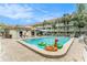Outdoor swimming pool surrounded by palm trees, lounge chairs, and a multi-story building at 801 83Rd N Ave # 120, St Petersburg, FL 33702