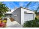 Gray townhome exterior with walkway, landscaping, and attached garage at 13635 Twin Lakes Ln # 13635, Tampa, FL 33618