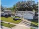 Single-story home with a white exterior, palm tree, and garage at 1392 Overlea Dr, Dunedin, FL 34698