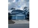 Two-story light blue house with a three-car garage and landscaping at 19820 Lonesome Pine Dr, Land O Lakes, FL 34638