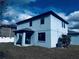 Back view of a two-story light blue house with covered patio at 19820 Lonesome Pine Dr, Land O Lakes, FL 34638