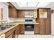 Well-lit kitchen featuring wood cabinetry and white tile floors at 22368 Southshore Dr, Land O Lakes, FL 34639
