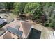 Aerial view of a home's rooftop solar panels, mature trees, and ample outdoor space at 2359 Gimlet Ave, Spring Hill, FL 34608