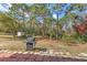 The backyard features a barbecue grill and a quaint red brick patio area at 2359 Gimlet Ave, Spring Hill, FL 34608